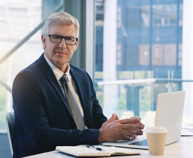 Portrait d'homme d'affaires professionnel et au bureau avec un ordinateur portable pour la communication et la connectivité Entreprise et directeur ou patron d'une agence avec un ordinateur pour la mise en réseau et Internet au travail