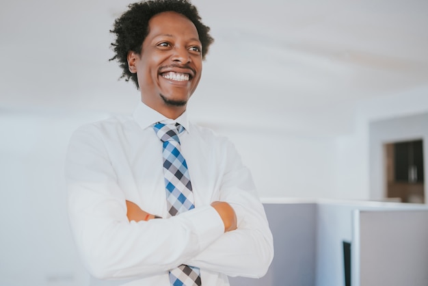 Portrait d'homme d'affaires professionnel souriant tout en se tenant au bureau moderne. Concept d'entreprise et de réussite.