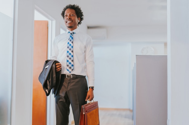 Portrait d'homme d'affaires professionnel tenant une mallette en se tenant debout au bureau moderne. Concept d'entreprise.