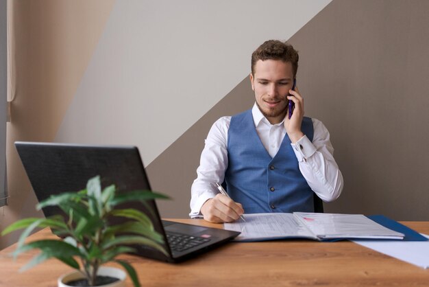 Portrait homme d'affaires prospère avec barbe à l'aide de smartphone et de travail