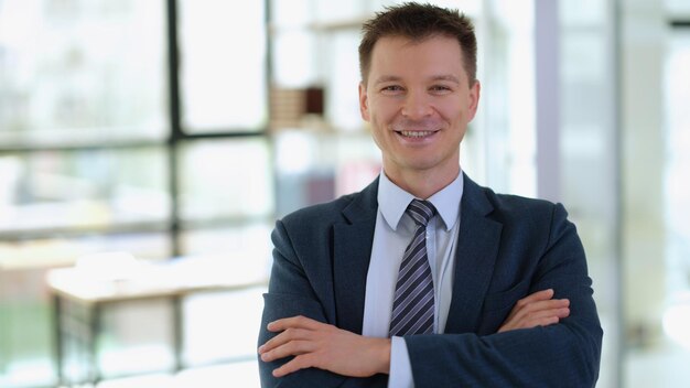 Portrait d'homme d'affaires prospère souriant avec les bras croisés