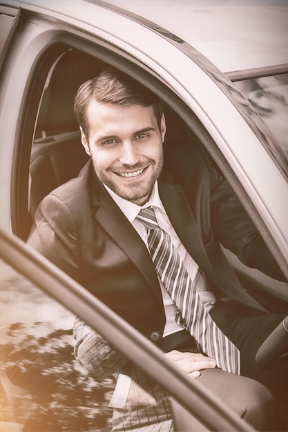 Portrait d'un homme d'affaires souriant assis sur le siège du conducteur dans sa voiture