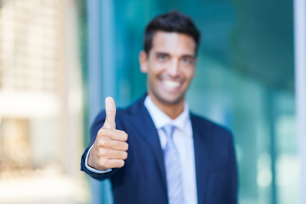 Portrait d&#39;un homme d&#39;affaires souriant donnant les pouces vers le haut