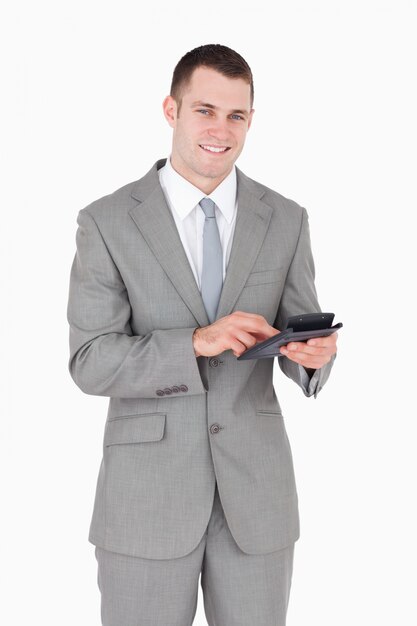 Portrait d&#39;un homme d&#39;affaires souriant travaillant avec une calculatrice