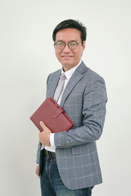 Portrait d'un homme d'affaires souriant en veste et tenant un journal