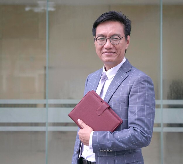 Portrait d'un homme d'affaires souriant en veste et tenant un journal