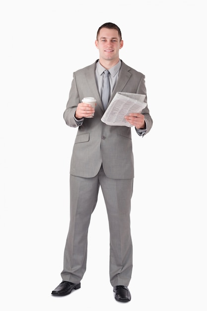 Portrait d&#39;un homme d&#39;affaires tenant un journal et une tasse de café