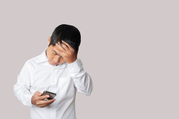 Portrait d'homme d'affaires utilisant un smartphone se sentant déçu geste malheureux et négatif Concept d'expression de visage d'émotion humaine Studio tourné isolé sur fond gris espace de copie