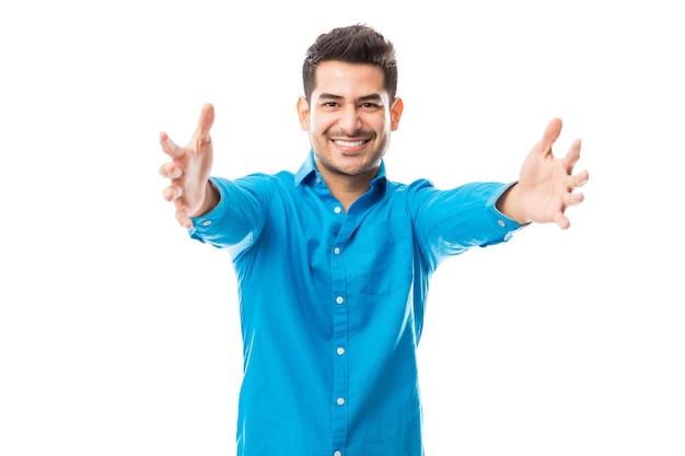 Portrait d'homme affectueux souriant tout en offrant un câlin sur fond blanc