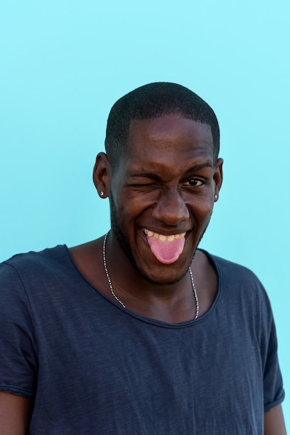 Photo portrait d'un homme africain drôle devant un mur coloré