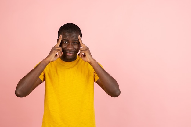 Portrait d'un homme africain isolé sur un mur de studio rose