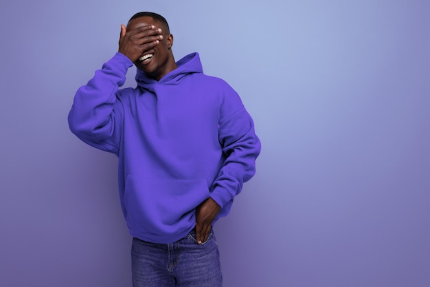 Portrait d'un homme africain à la peau sombre en sweat à capuche avec des émotions de doute et de déni sur