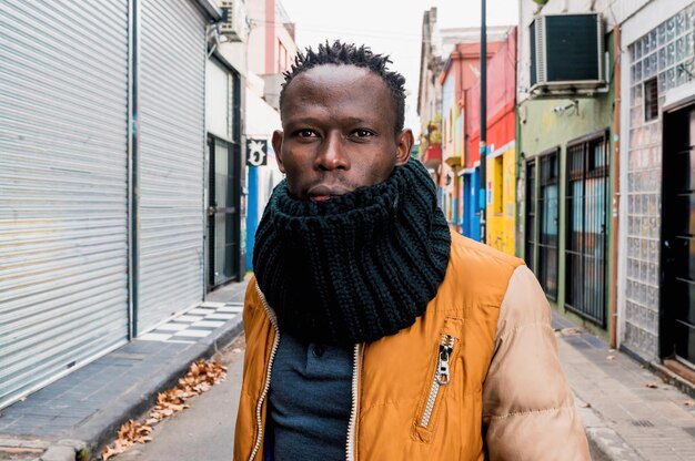 portrait d'un homme africain en vêtements d'hiver debout au milieu de la rue