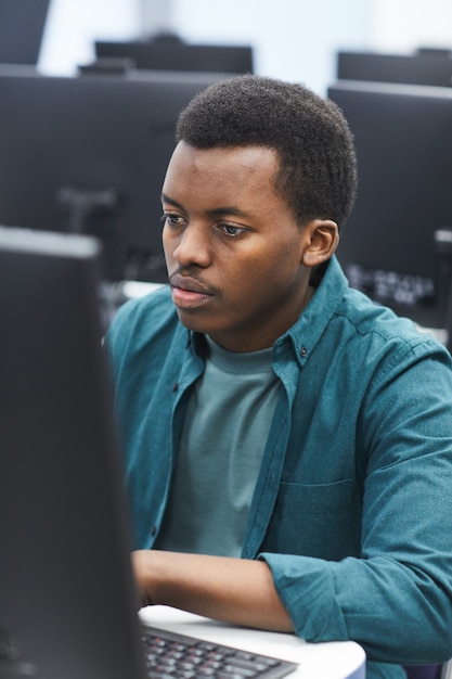 Photo portrait d'un homme afro-américain à l'aide d'ordinateur en classe de bibliothèque universitaire