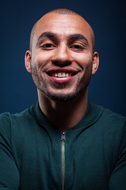 Portrait d&#39;un homme afro-américain souriant sur bleu foncé