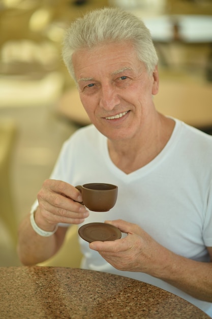 Portrait d'un homme âgé buvant une tasse de café