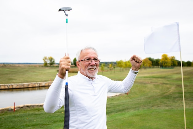 Portrait d'un homme âgé célébrant sa victoire sur le terrain de golf et profitant du temps libre à l'extérieur