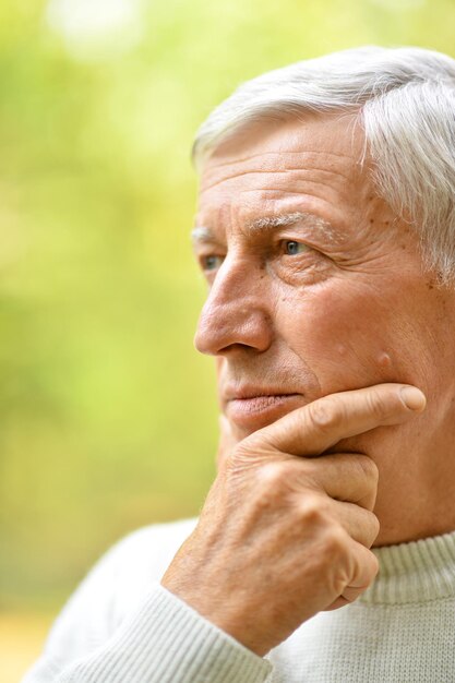 Portrait d'un homme âgé dans le parc sur fond vert