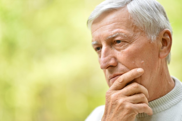 Portrait d'un homme âgé dans le parc sur fond vert