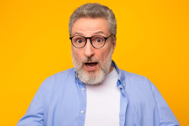 Portrait d'un homme âgé émotionnellement choqué avec des cheveux gris studio