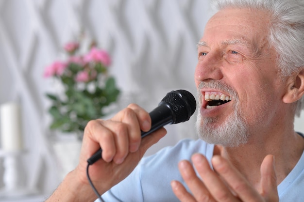 Portrait d'un homme âgé excité tenant un microphone