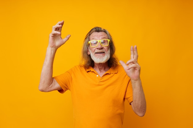 Portrait d'un homme âgé heureux gestes de la main émotions lunettes jaunes fond isolé