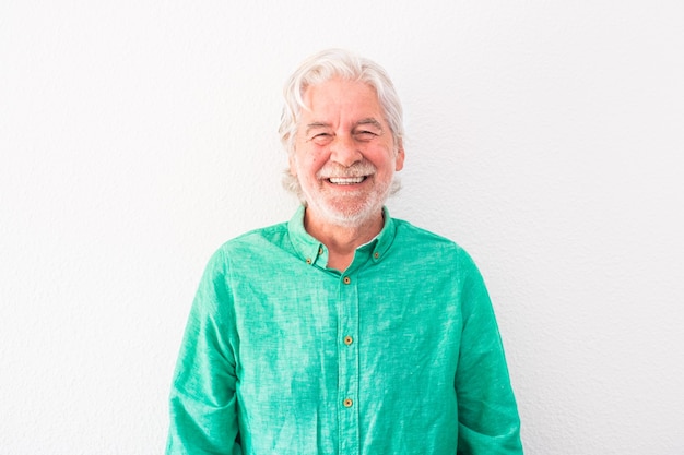 Photo portrait d'un homme âgé et mature regardant la caméra en souriant et en riant - senior heureux avec fond blanc