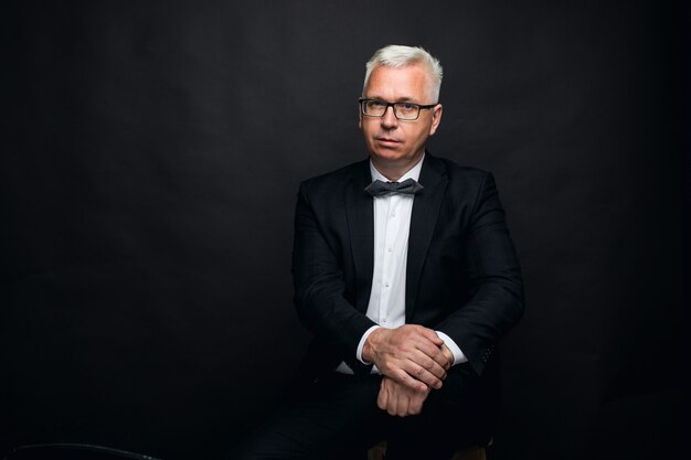 portrait d'un homme d'âge moyen aux cheveux blancs portant des lunettes.