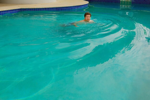 Portrait d'un homme d'âge moyen heureux nager dans la piscine