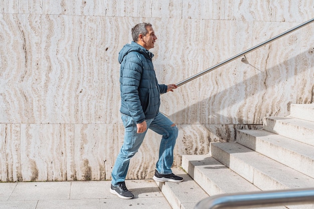 Portrait homme d'âge moyen positif sur fond de mur de marbre avec marches