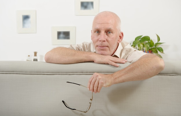 Portrait d'un homme d'âge mûr assis sur un canapé