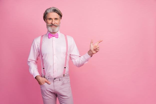 Portrait d'homme d'âge mûr aux cheveux gris montrant une copie de l'annonce de l'espace vide vide