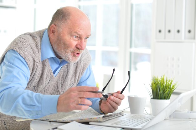 Portrait d'un homme âgé avec un ordinateur portable