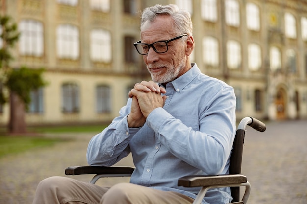 Portrait d'un homme âgé pensif patient handicapé en fauteuil roulant à la réflexion tout en dépensant