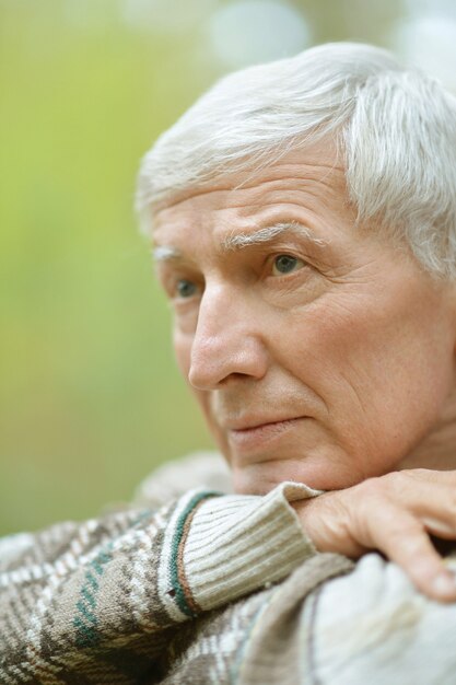 Portrait d'un homme âgé réfléchi sur fond d'automne jaune