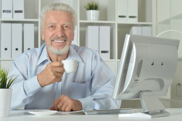 Portrait d'un homme âgé utilisant un ordinateur au bureau