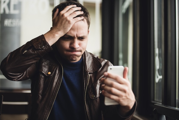 Portrait d'un homme à l'aide de son smartphone