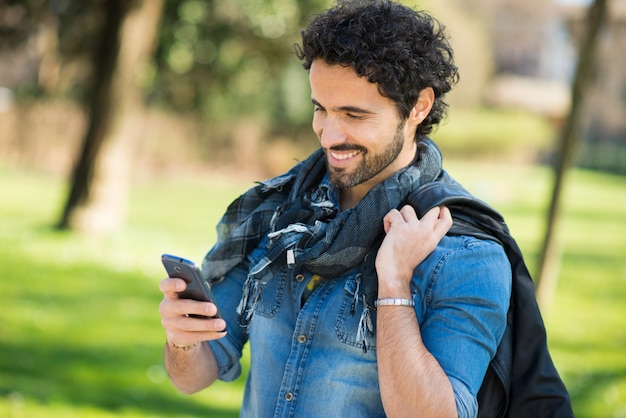 Portrait d&#39;un homme à l&#39;aide de son téléphone portable dans un parc