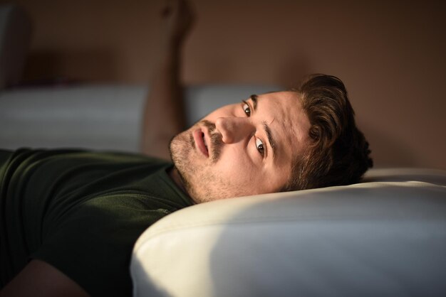 Photo portrait d'un homme allongé sur un lit à la maison