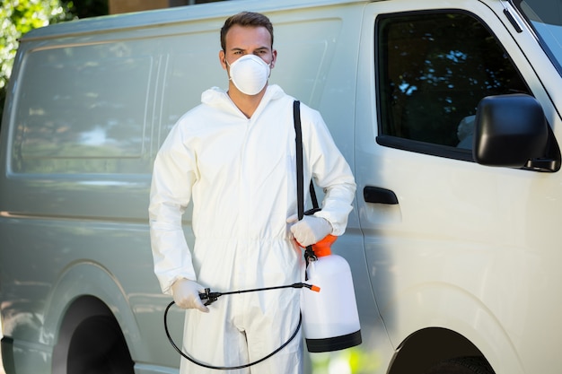 Portrait d'homme antiparasitaire debout à côté d'une camionnette