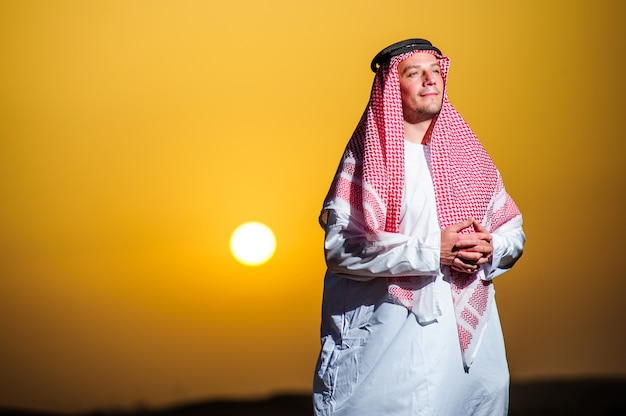 Portrait d'homme arabe assoiffé sur un milieu de désert jaune.