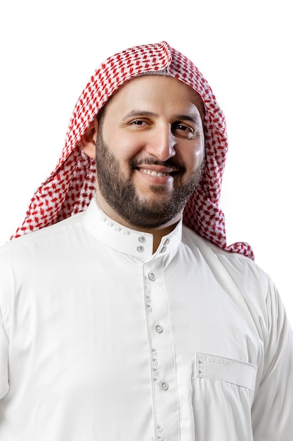 Portrait de l'homme arabe souriant isolé sur fond de studio blanc. Nationalité, culture, inclusion, diversité. Homme d'affaires confiant en vêtements traditionnels du Moyen-Orient avec foulard. Entreprise.