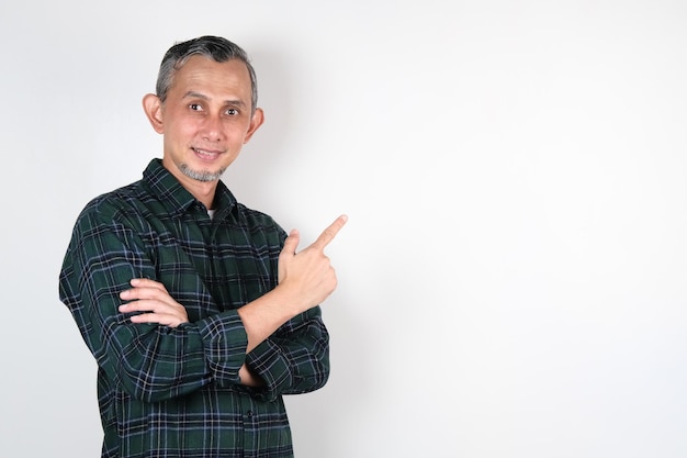 Portrait d'un homme asiatique adulte pointant avec les mains et le doigt sur le côté pour expliquer quelque chose