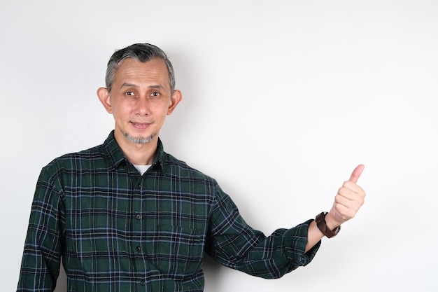 Portrait d'un homme asiatique avec une chemise décontractée faisant un geste positif avec les pouces vers le haut