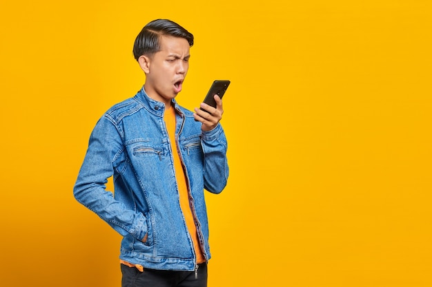 Portrait d'un homme asiatique en colère lorsqu'il parle au smartphone