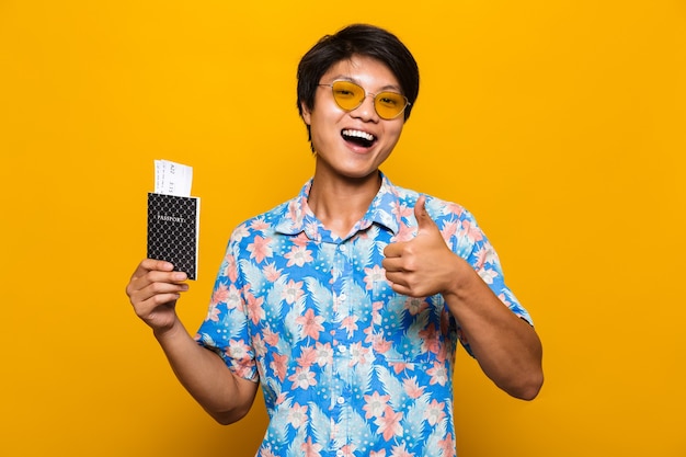 Portrait d'un homme asiatique excité isolé sur jaune