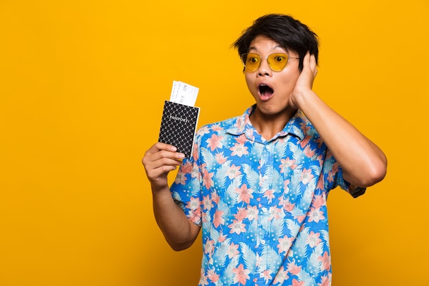 Portrait d'un homme asiatique excité isolé sur jaune