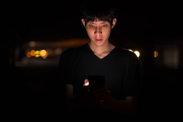 Portrait D'un Homme Asiatique à L'extérieur La Nuit Dans Un Parking à L'aide De Mob