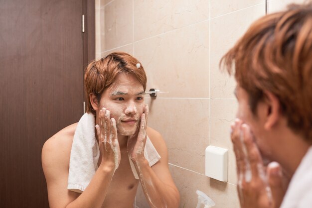 Portrait d'un homme asiatique lavant dans la salle de bain