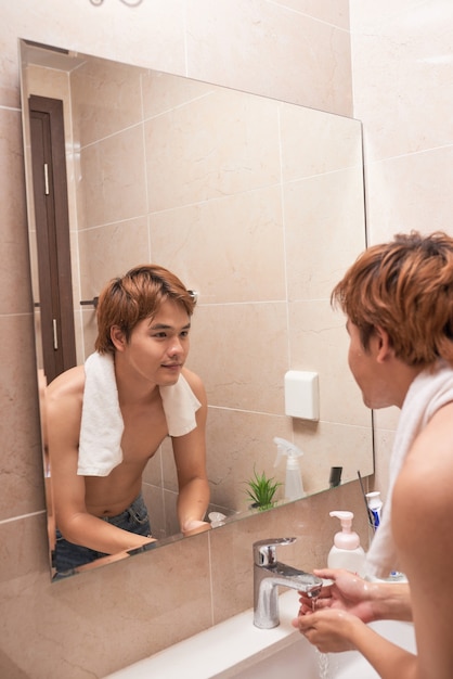 Portrait d'un homme asiatique lavant dans la salle de bain